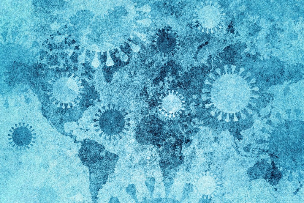 A world map with renderings of the coronavirus spread across it.