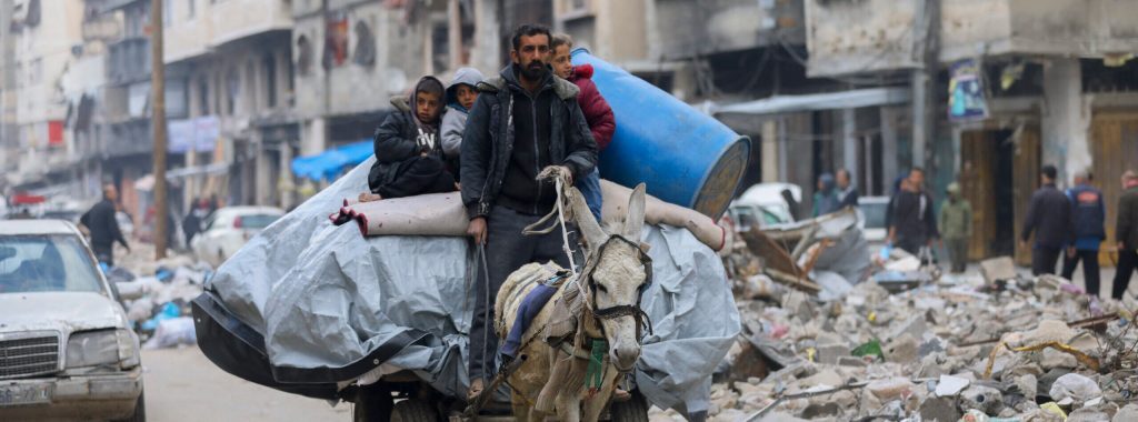The photo shows the cart headed toward the camera, against a backdrop of war-ravaged buildings.
