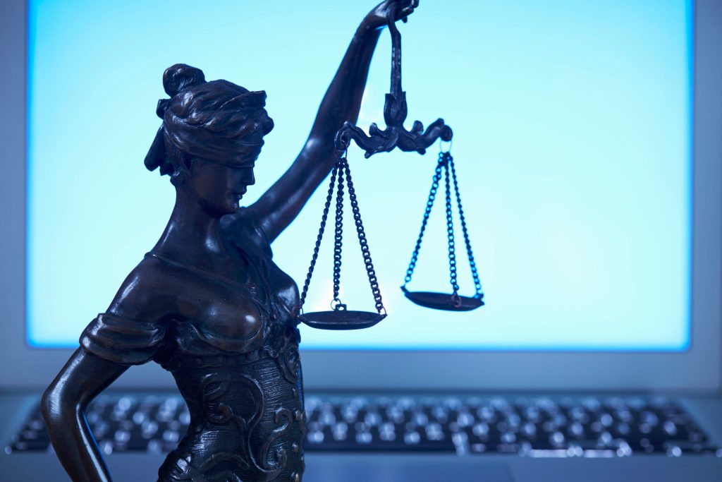 Lady Justice against laptop monitor