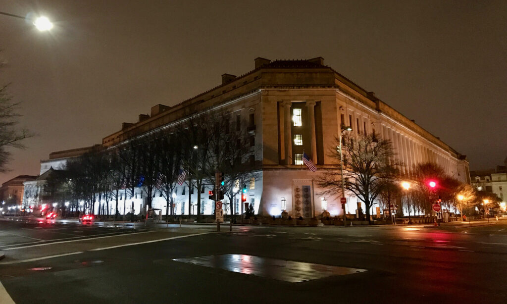 US Department of Justice building at night.