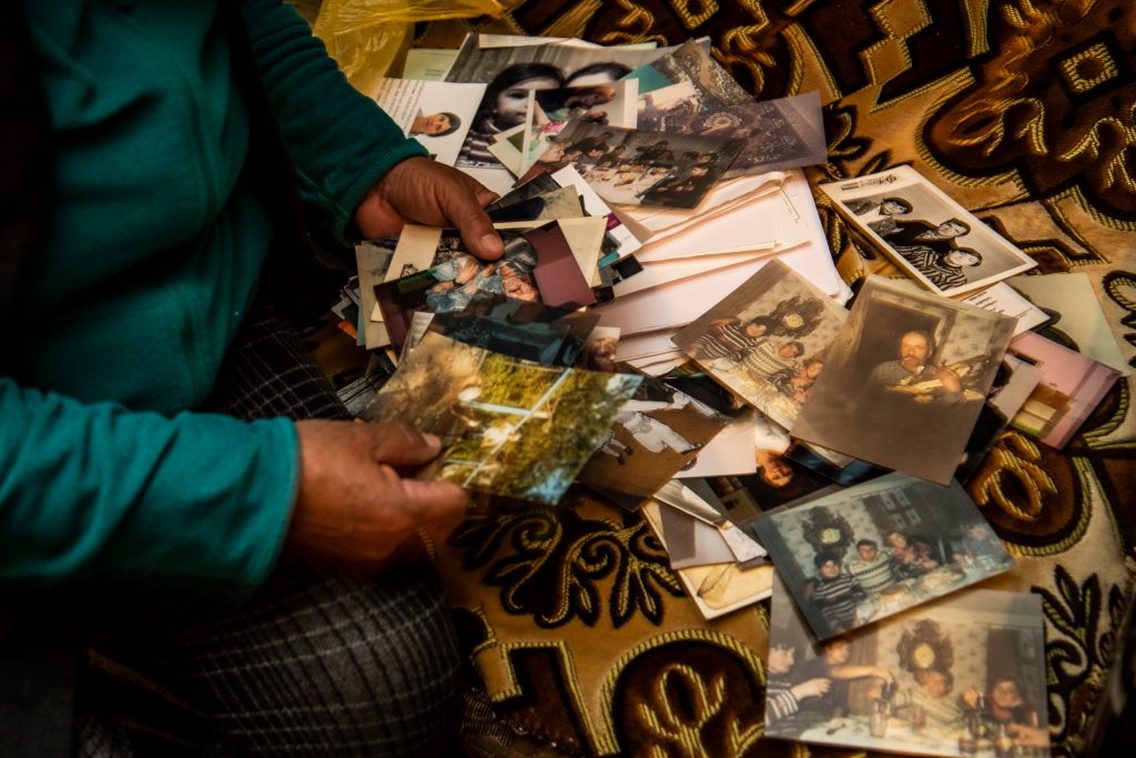 A woman displays photographs of her family.