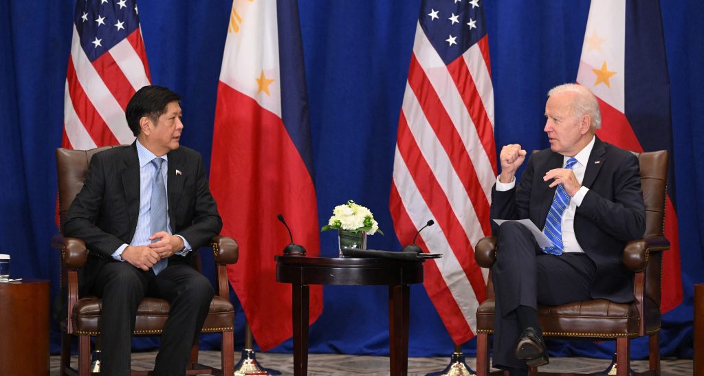 Marcos (L) and Biden (R) talk in front of the American and Philippine flags