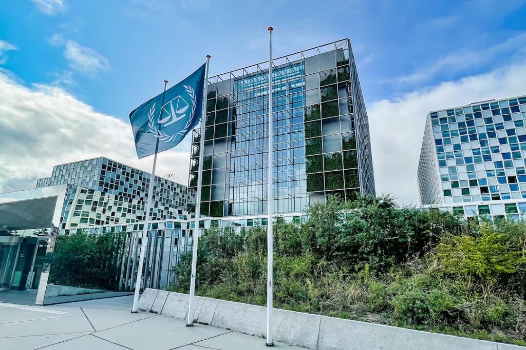 The blue flag of the International Criminal Court flies outside of the organization's headquarters.
