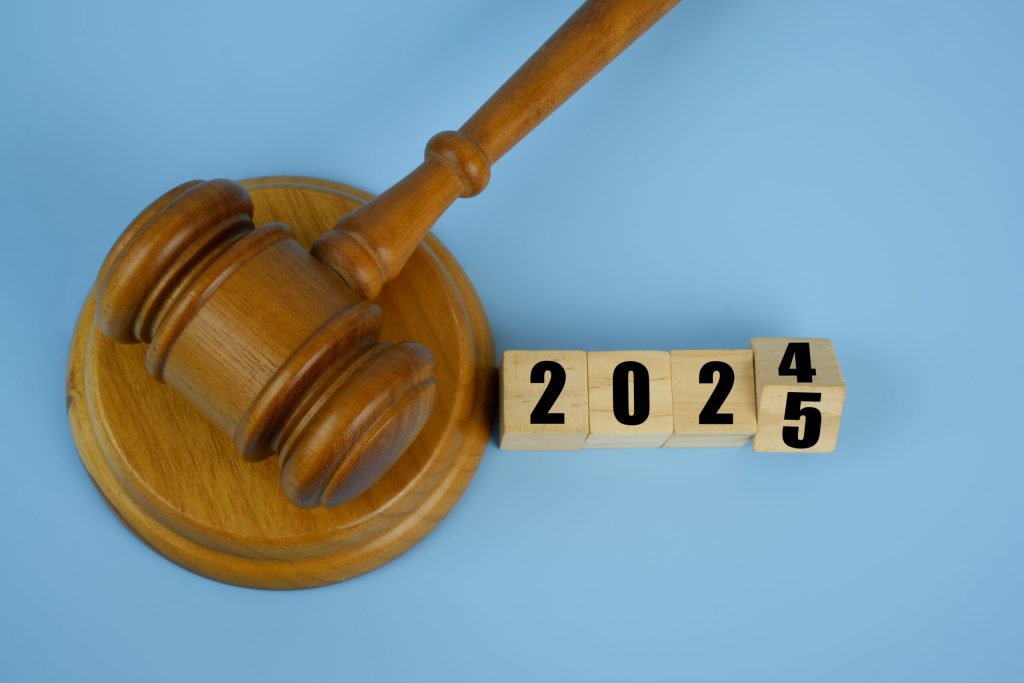 Wooden gavel and flipping numbers 2024 and 2025 on wooden cubes