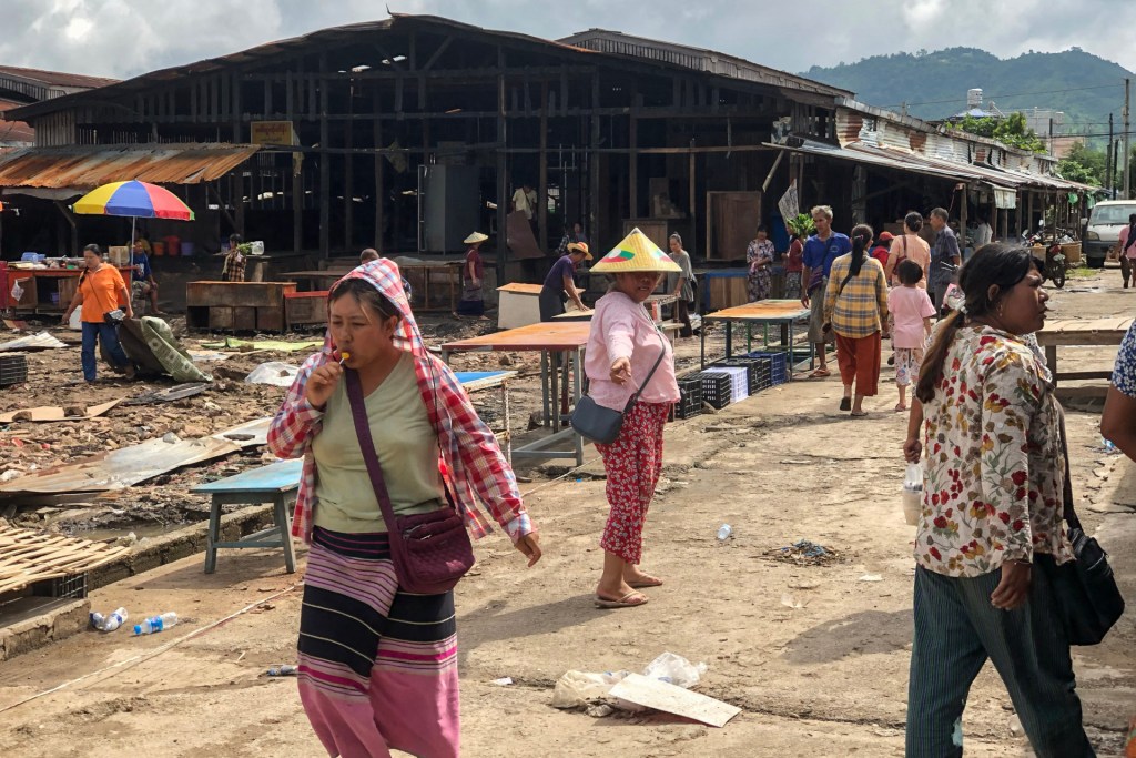 This photo taken on September 10, 2024 shows people walking though a market area being rebuilt in Lashio in Myanmar's northern Shan state, after the Myanmar National Democratic Alliance Army (MNDAA) seized the town from Myanmar's military in August. (Photo by STR/AFP via Getty Images)