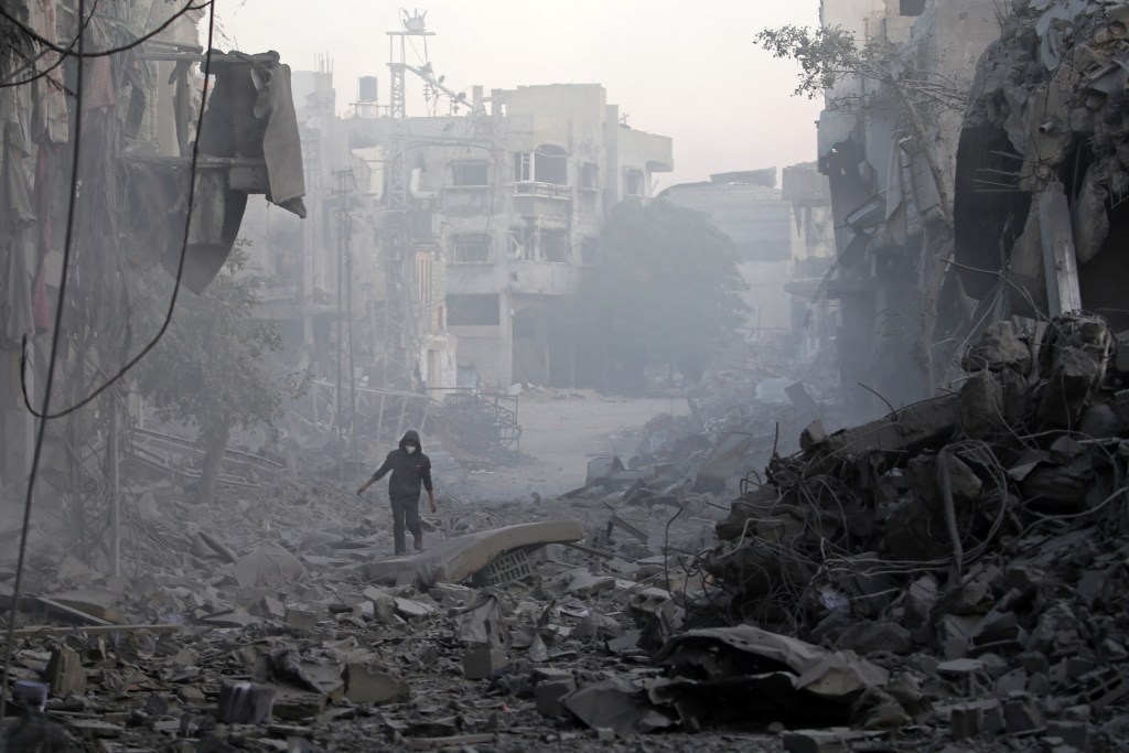 A man walks through the rubble of buildings destroyed in Israeli airstrikes at the Bureij camp for Palestinian refugees in the central Gaza Strip on January 12, 2025, as the war between Israel and Hamas militants continues. (Photo by EYAD BABA/AFP via Getty Images)
