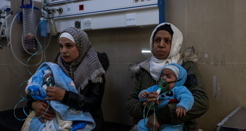 Newborns receive oxygen, sitting on the laps of their mothers.