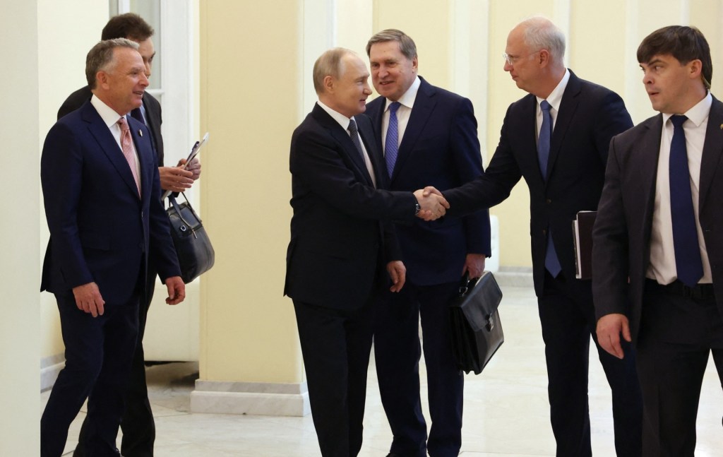 Vladimir Putin shakes hands with Kirill Dmitriev during a meeting with Steve Witkoff (left foreground)