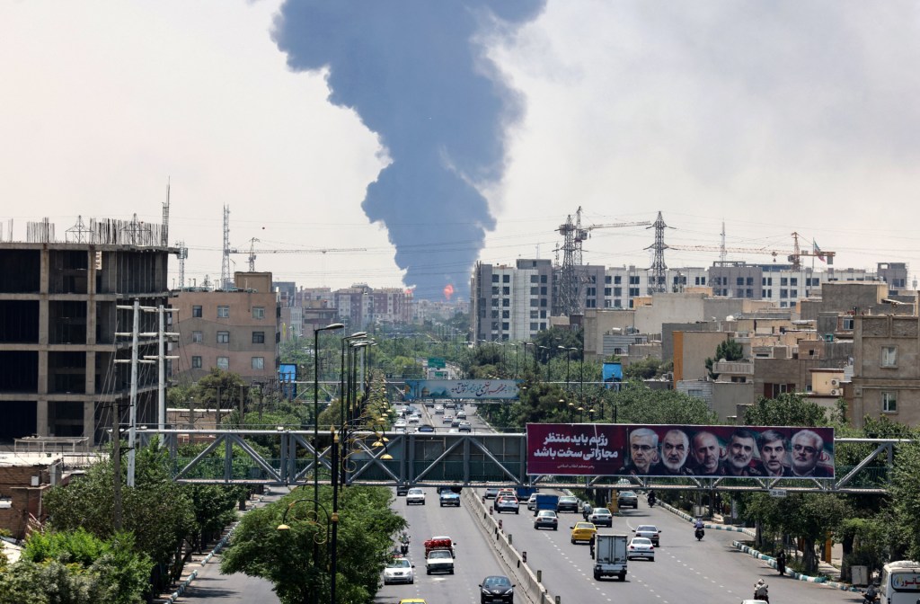plume of heavy smoke and fire rise from an oil refinery in southern Tehran