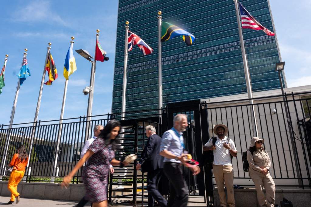 People walk past the United Nations (UN) headquarters in Manhattan