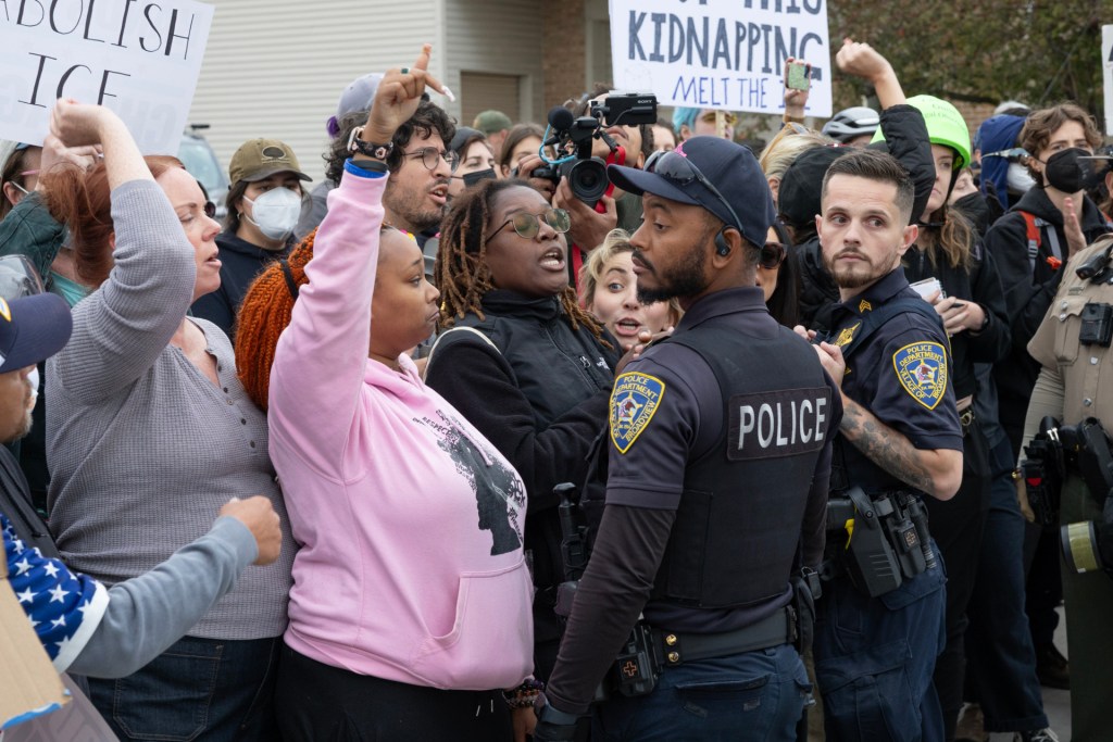 Demonstrators protest near police officers