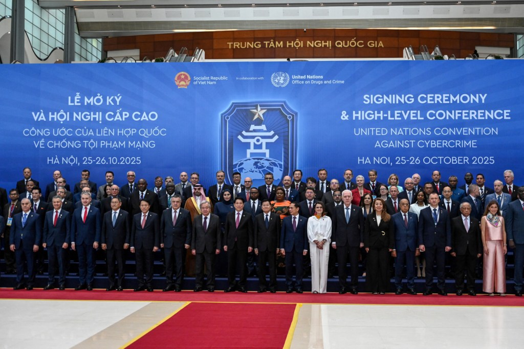 Delegates pose for photos at the signing ceremony of the United Nations Convention against Cybercrime