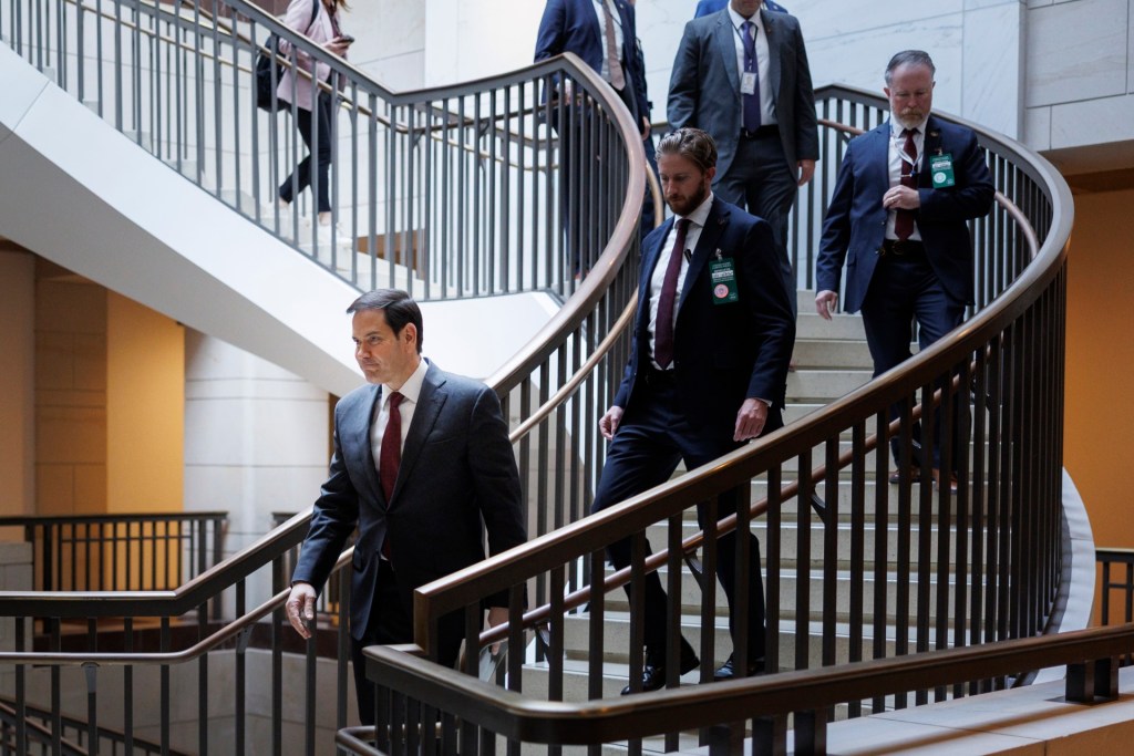 U.S. Secretary of State Marco Rubio walks down stairs