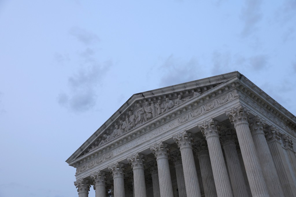 The Supreme Court building is shown with a blue sky behind it.